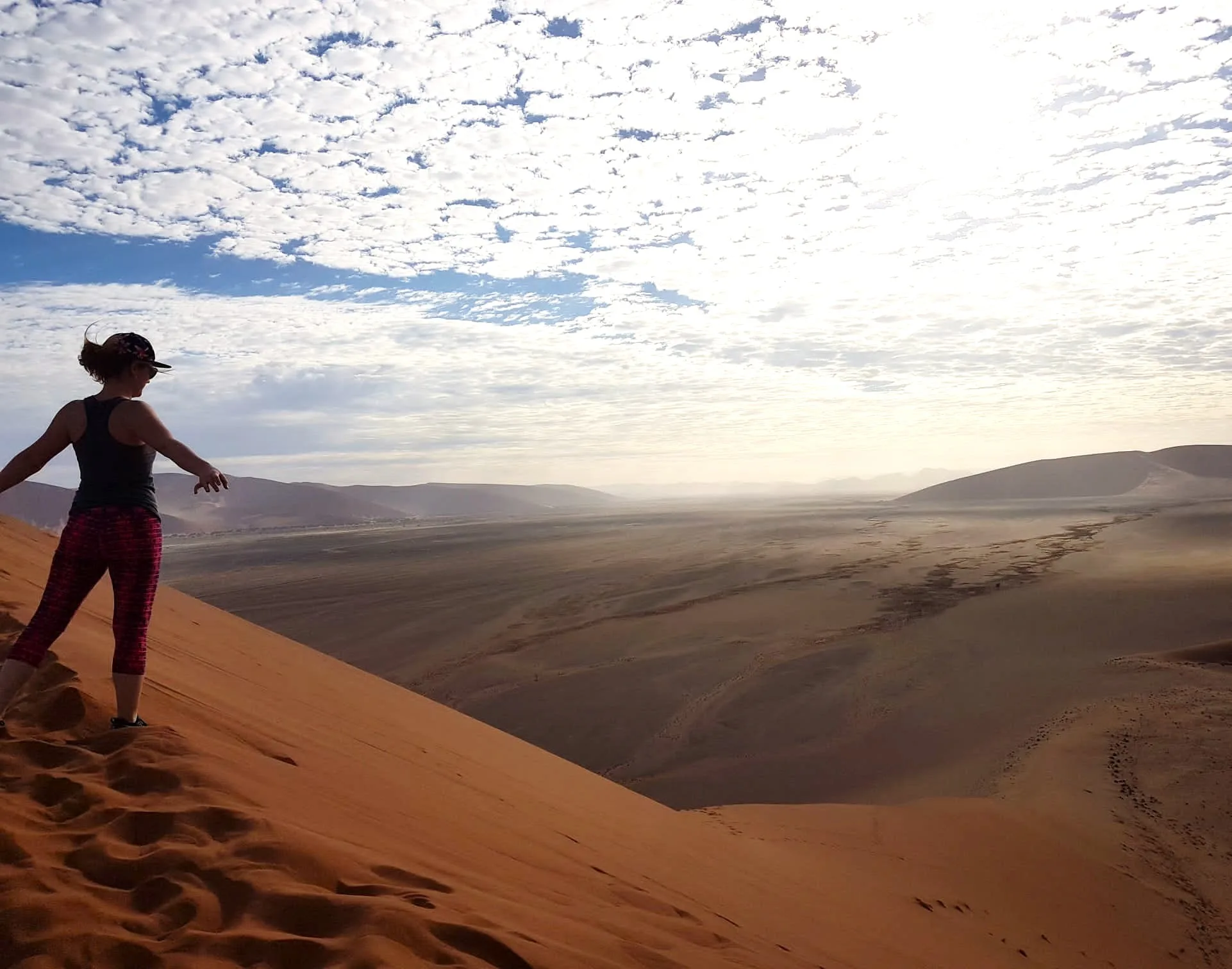 Visitor standing at the summit of Dune 7 near Walvis Bay with the full desert panorama spread below