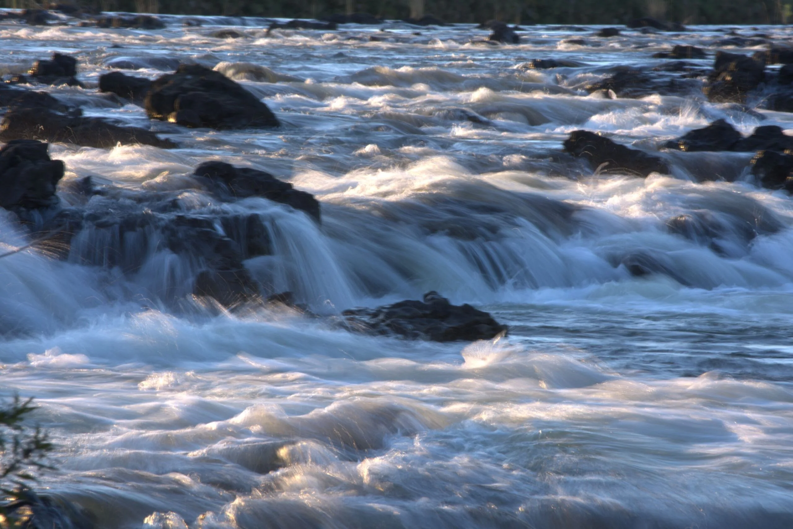 Long exposure shot of white water rushing over rocks at Popa Falls on the Okavango River
